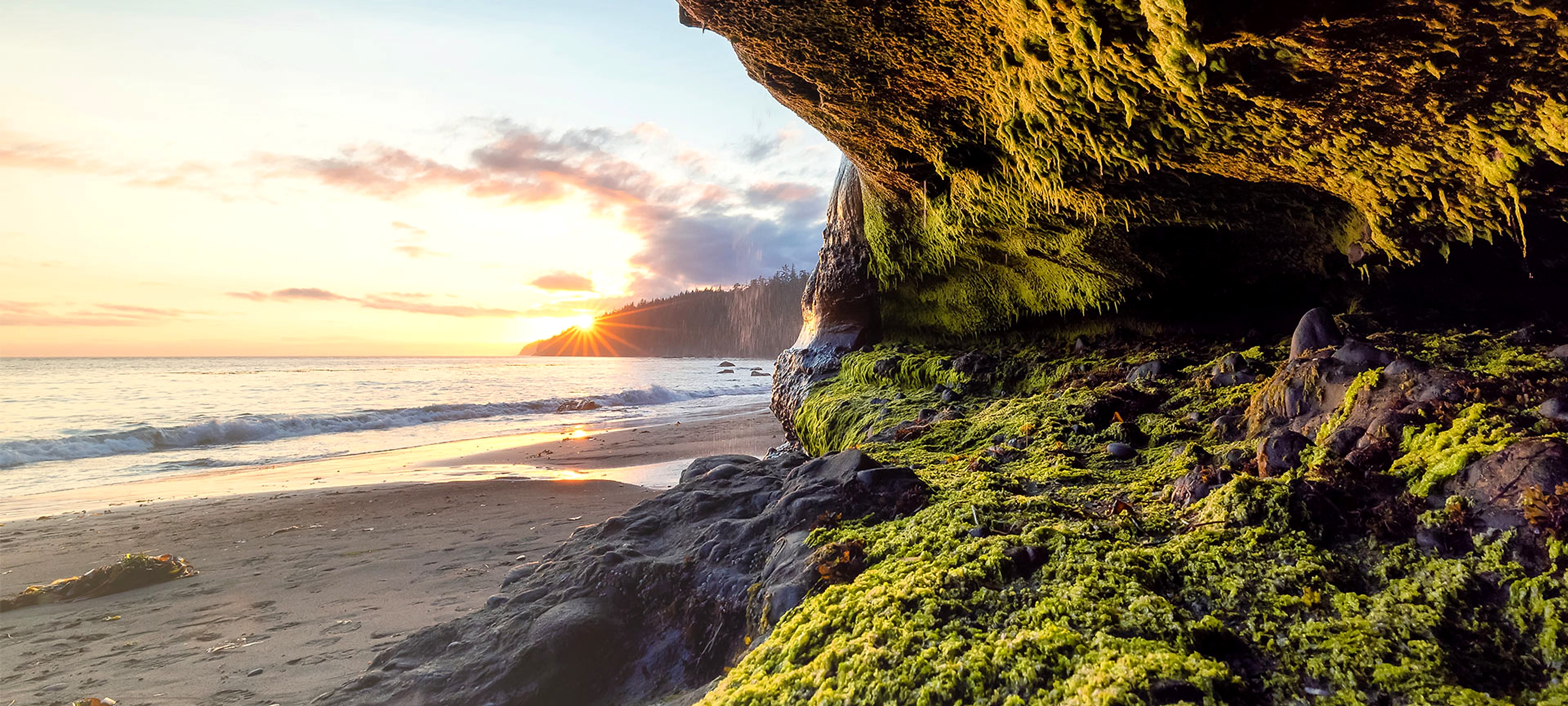A quiet sunrise breaking over a calm coastline