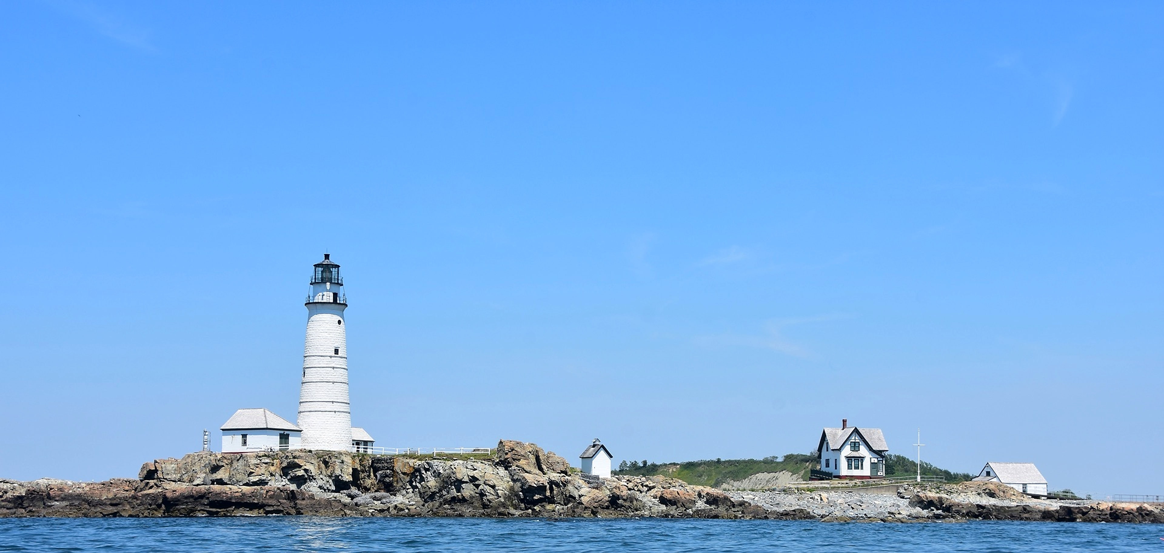 Boston Light standing watch over the harbor islands on a clear summer day