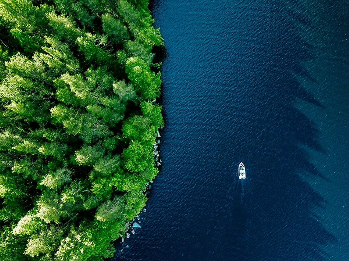 An aerial view of a boat on calm, deep water