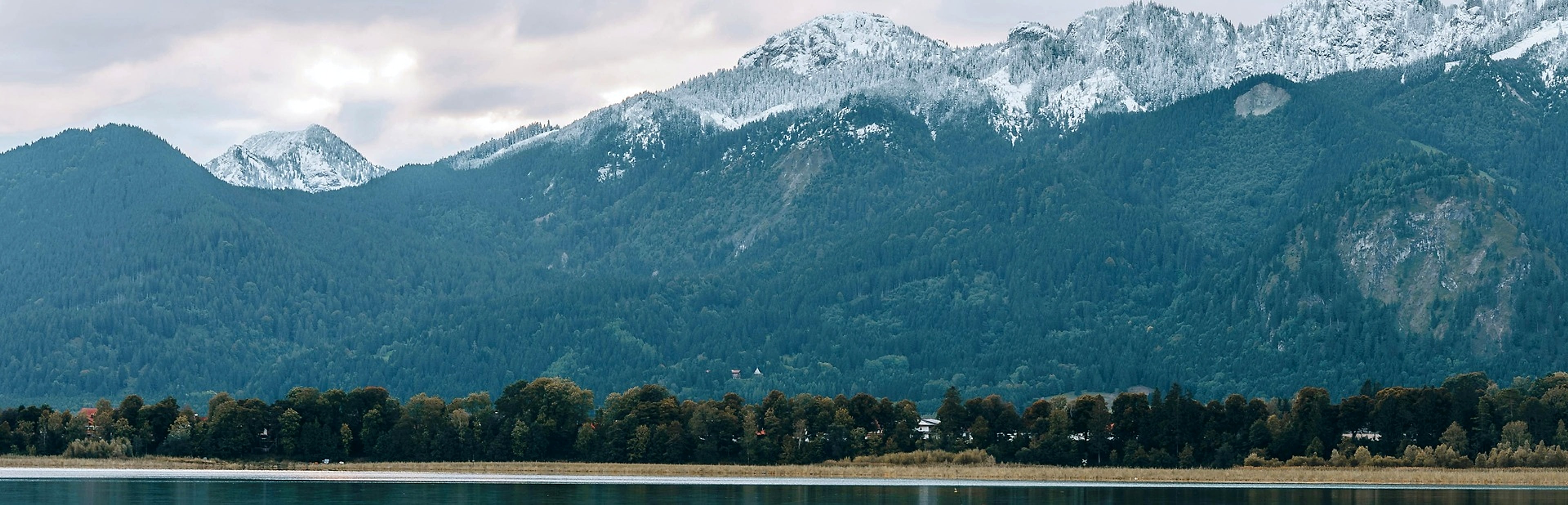 Snow-capped mountains standing firm above a still lake