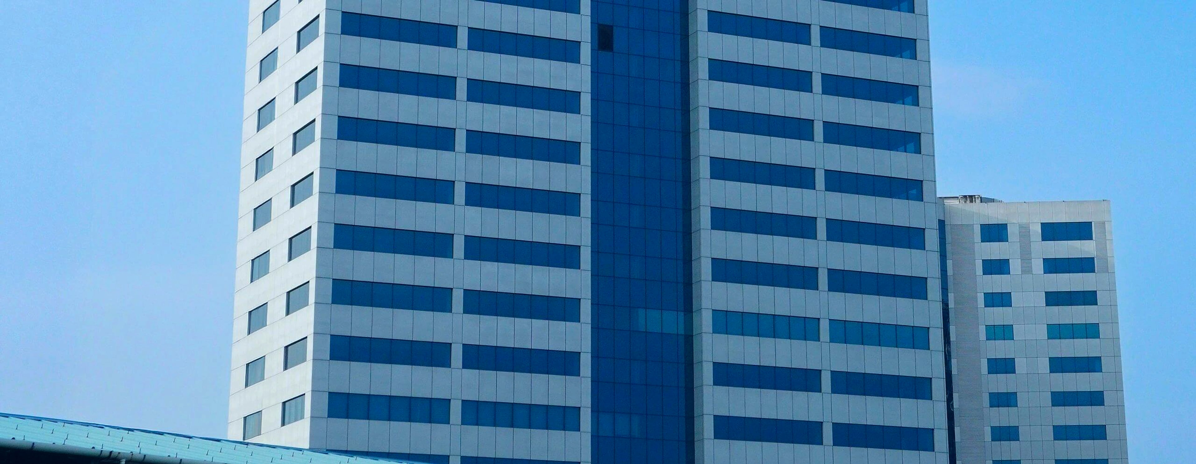 A modern commercial office tower against a clear sky